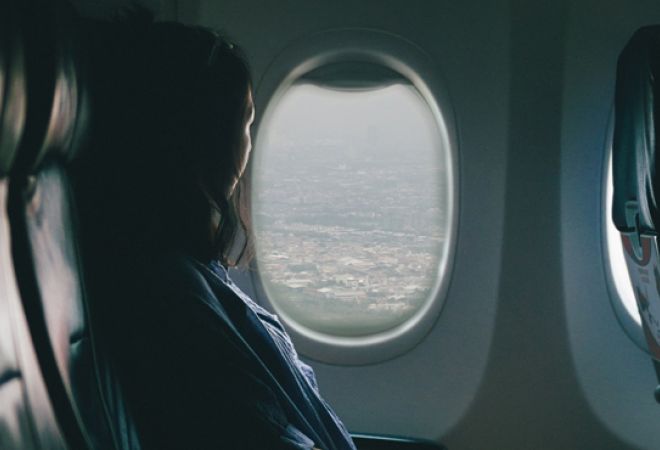 Woman looking out of an airplane window